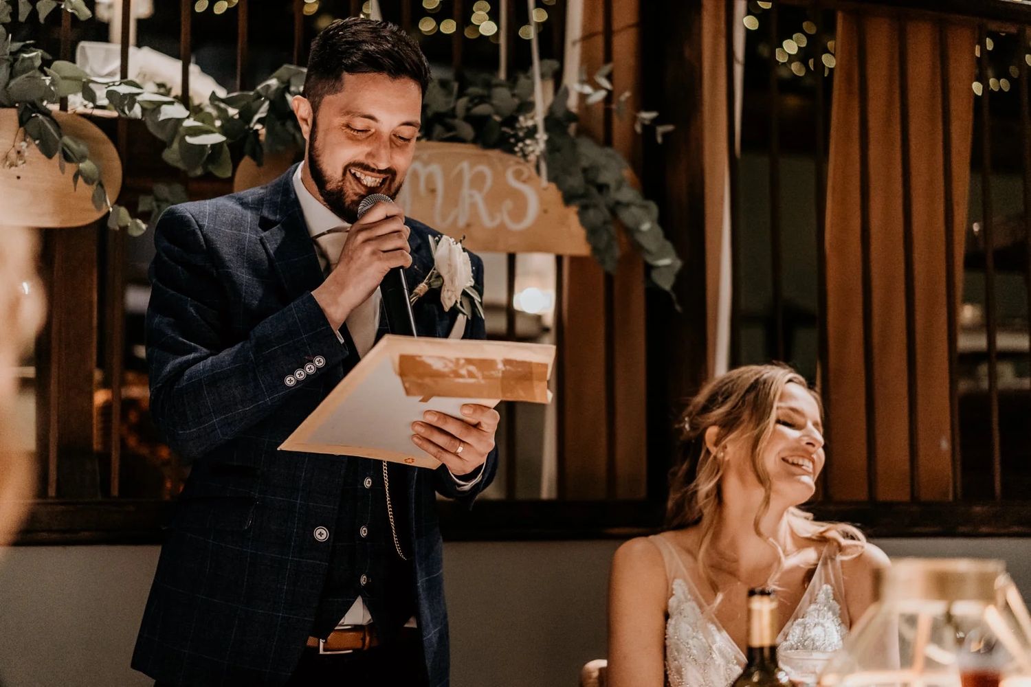 Wedding guests stand and mingle during an elegant indoor reception celebration.