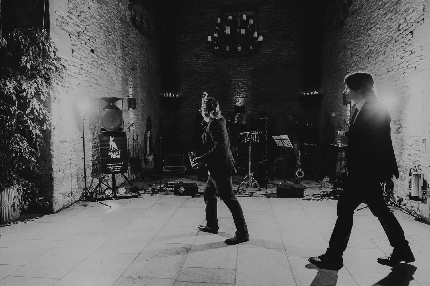 Black and white photo of people dancing at a nighttime wedding celebration.