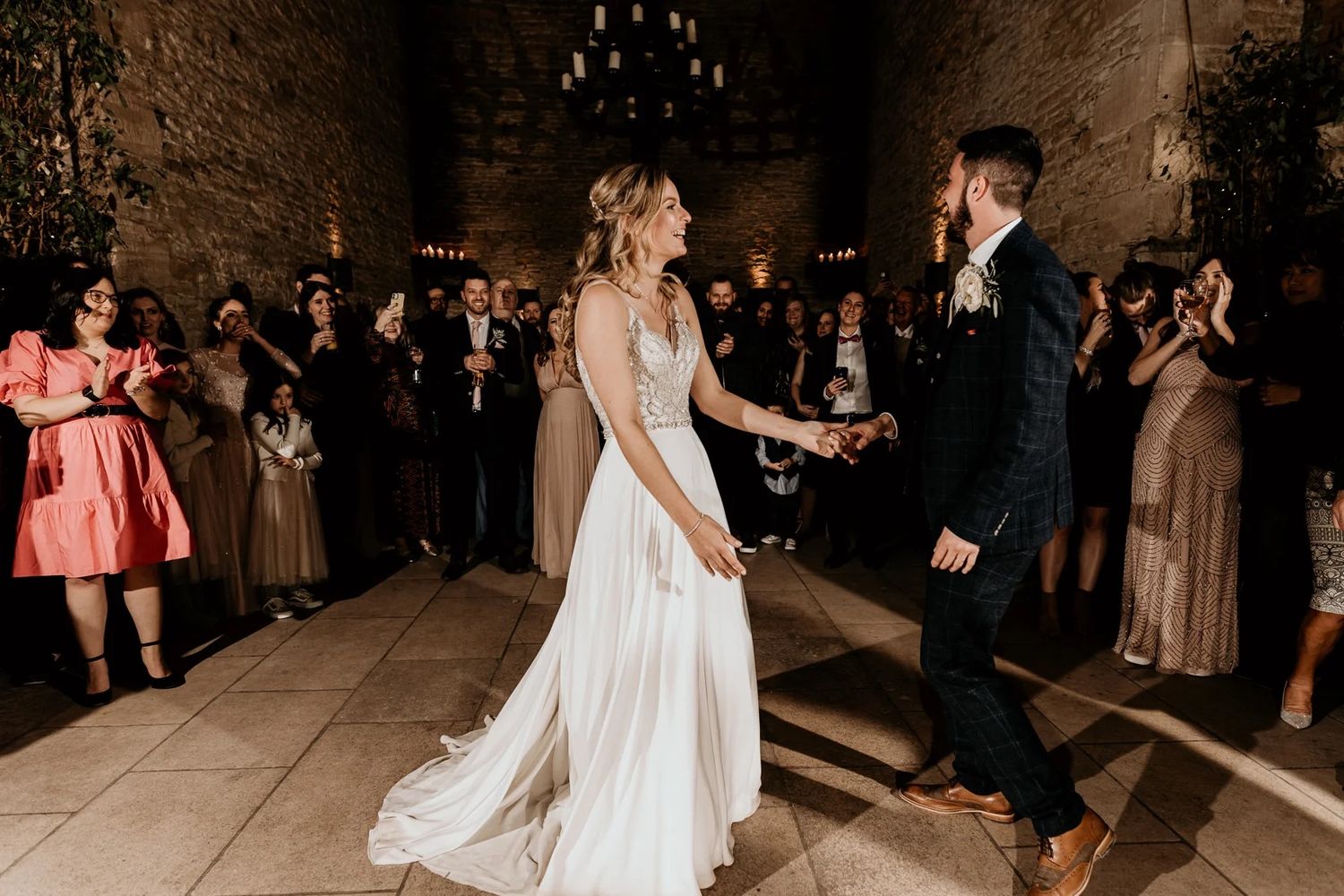 Wedding celebration on a dimly lit dance floor with guests dancing and enjoying the festivities.