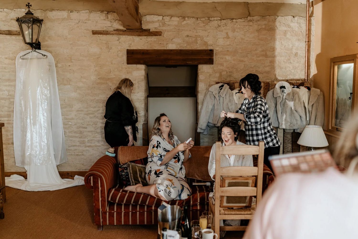 Guests gather in a rustic indoor venue with stone walls and warm lighting for a celebration.