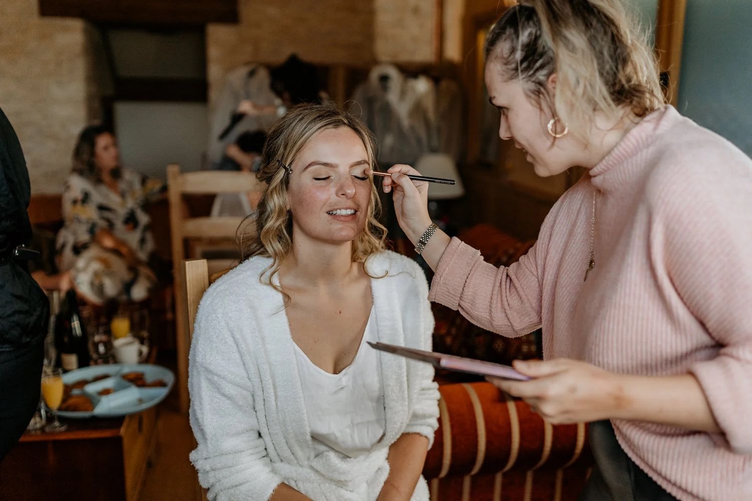 Candid moments of wedding day preparation in a sunlit room.
