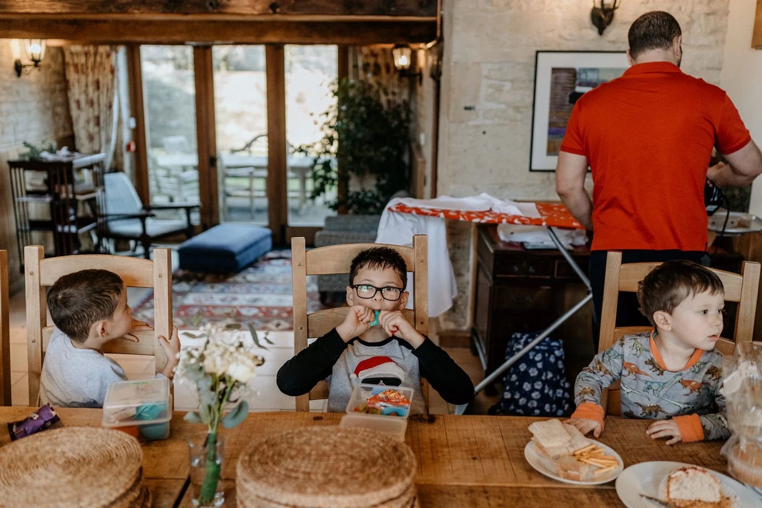 Children play and relax in a rustic room with exposed wooden beams and natural lighting.