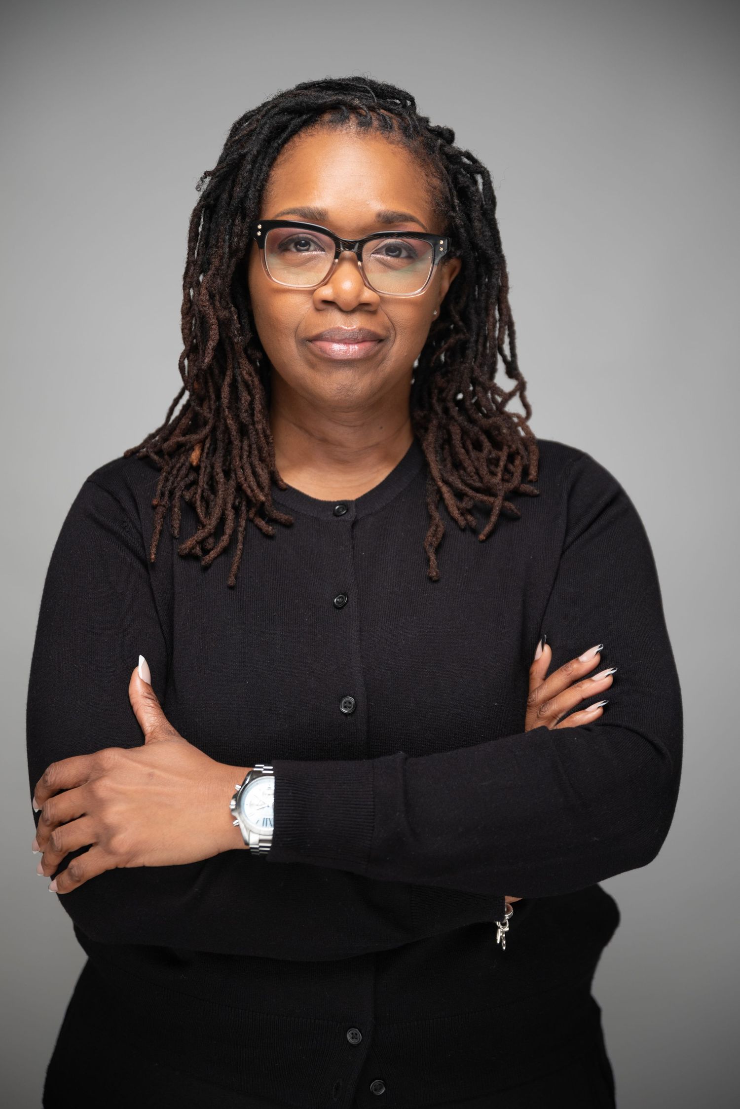 Professional headshots in black attire against a grey background showing confident poses.