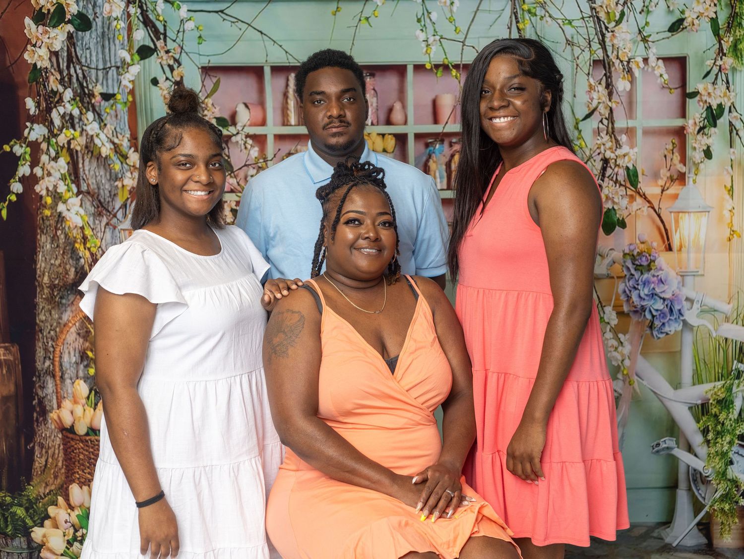 Group photo with family members wearing coordinated orange and white outfits.
