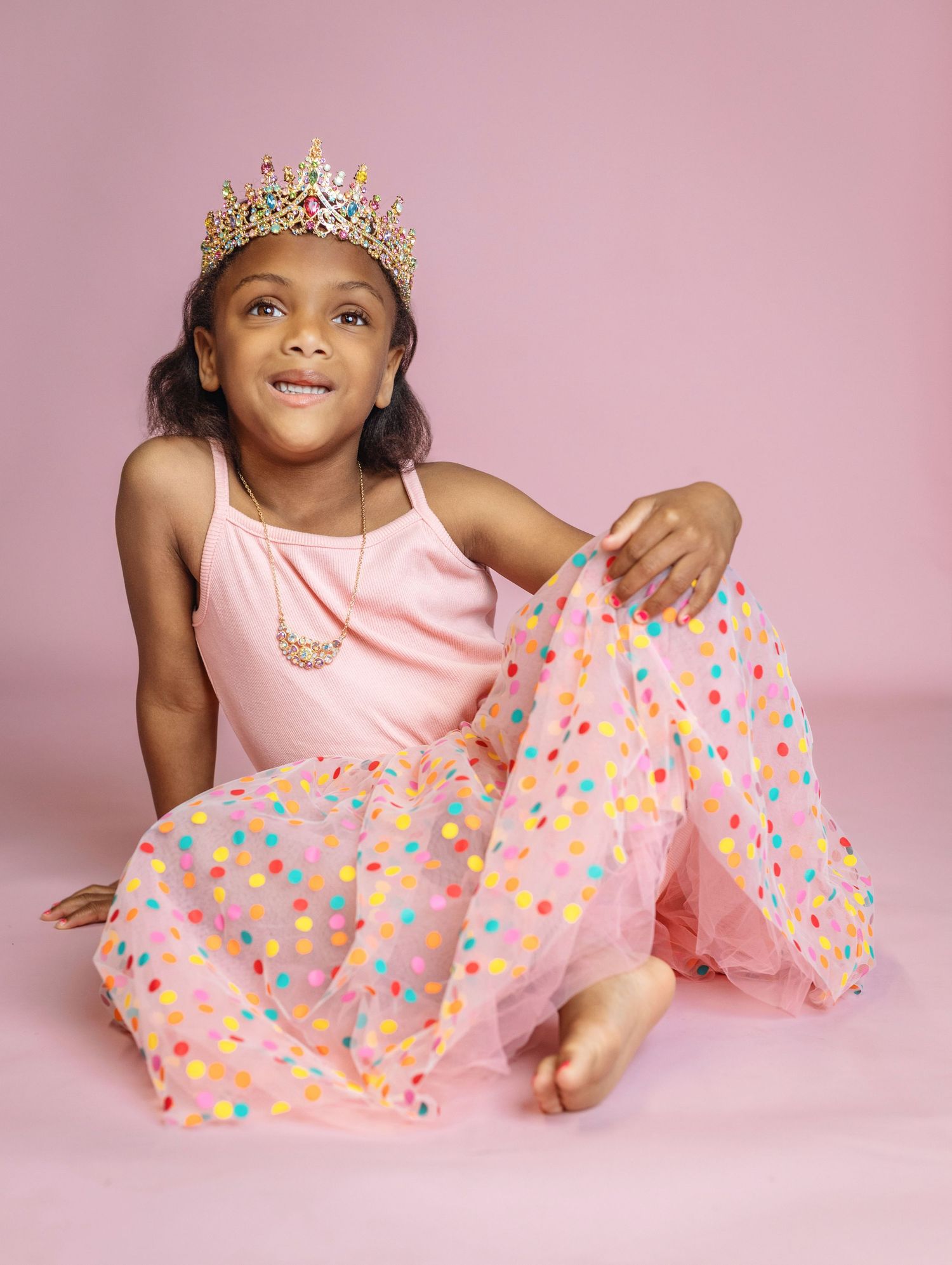 Pink princess themed photoshoot with tulle dress and polka dot patterns.