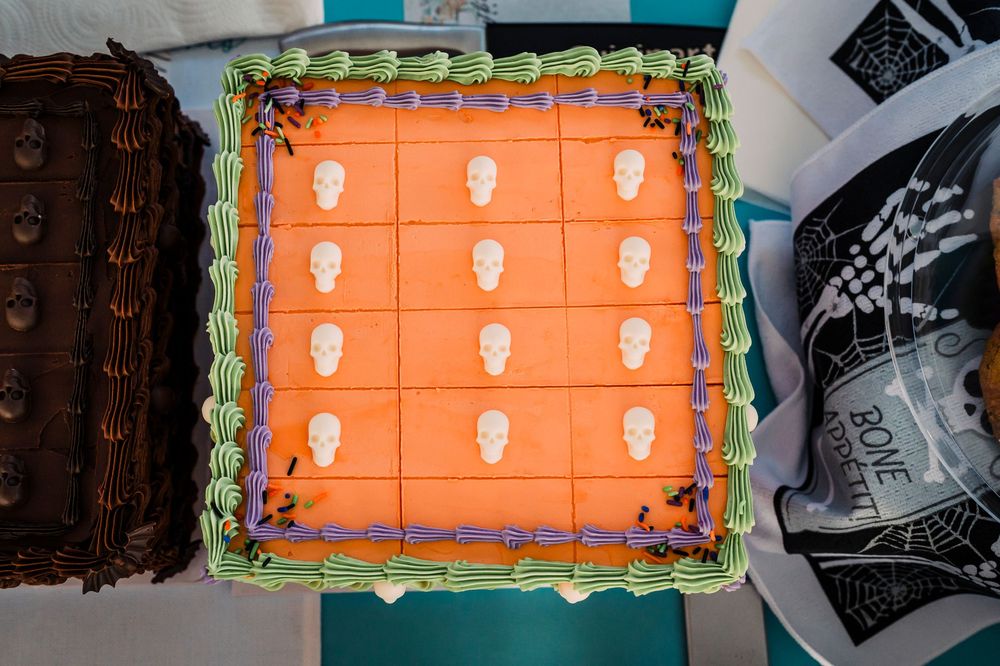 Orange cake decorated with white skull designs in a grid pattern.