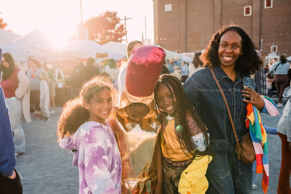 People enjoying an outdoor community event at sunset with colorful tie-dye clothing and festive atmosphere.