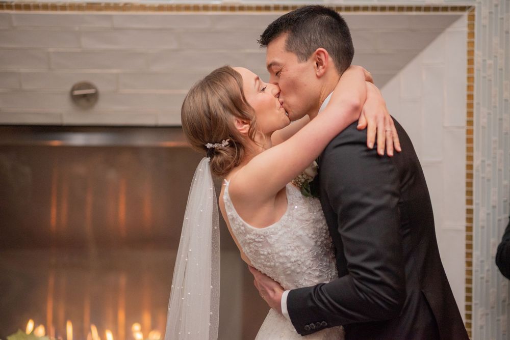 Restaurant e18hteen wedding ceremony first kiss at fireplace