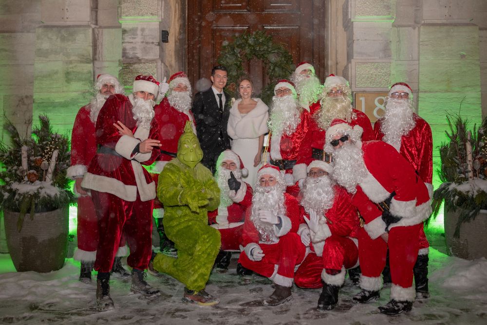 Bride and groom pose with group of Santas outside Restaurant e18hteen in Ottawa