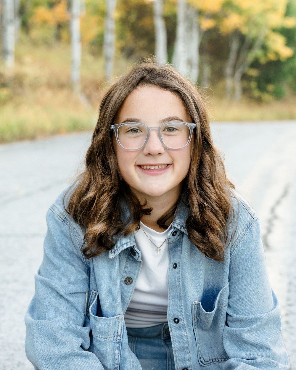 A series of four casual portraits showing someone in a denim jacket and glasses against a light outdoor background.