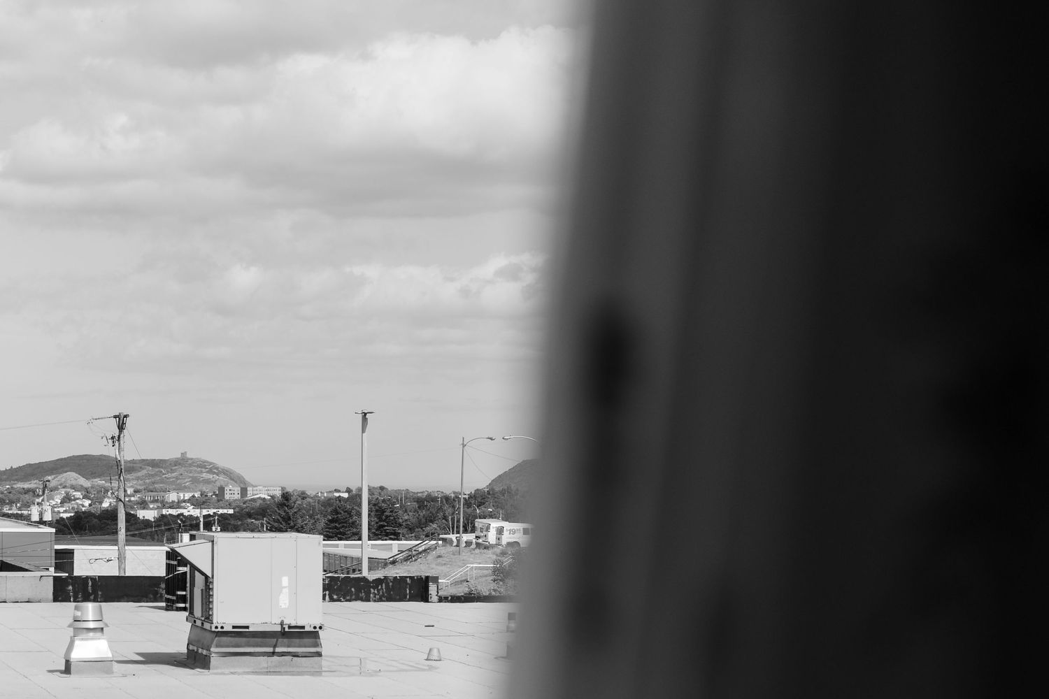Military ships and installations in black and white panoramic view across a harbor during wartime.