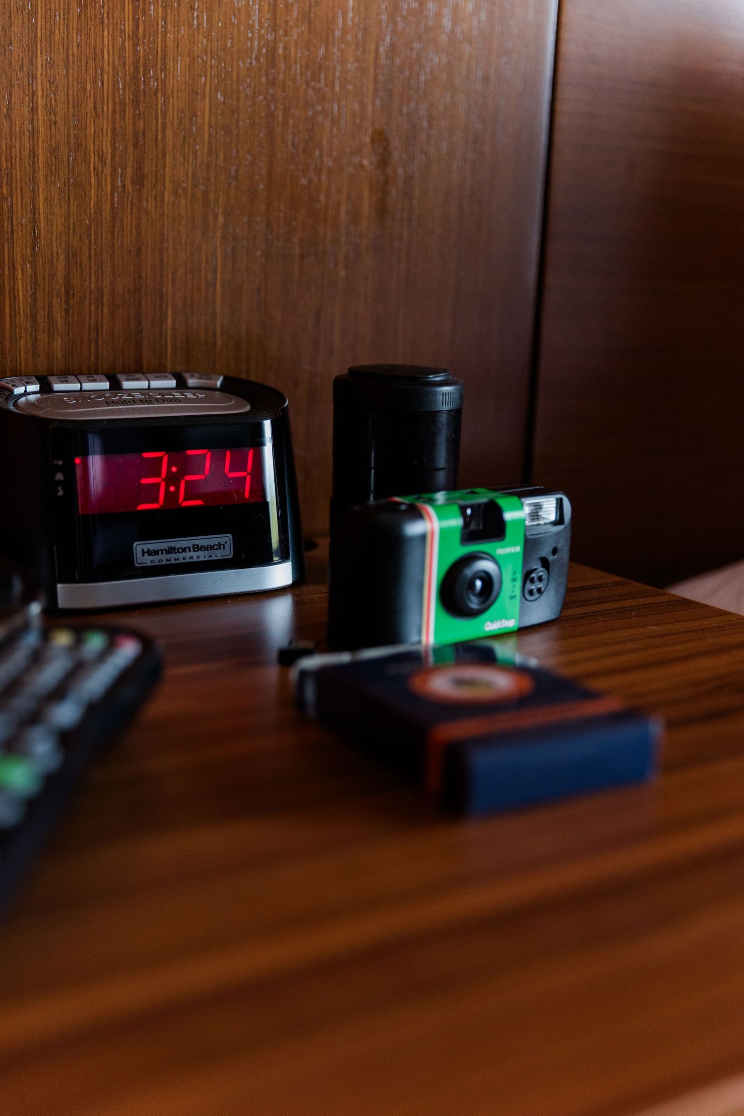Vintage cassette tape players with glowing display screens sit on a wooden surface in dark lighting conditions.