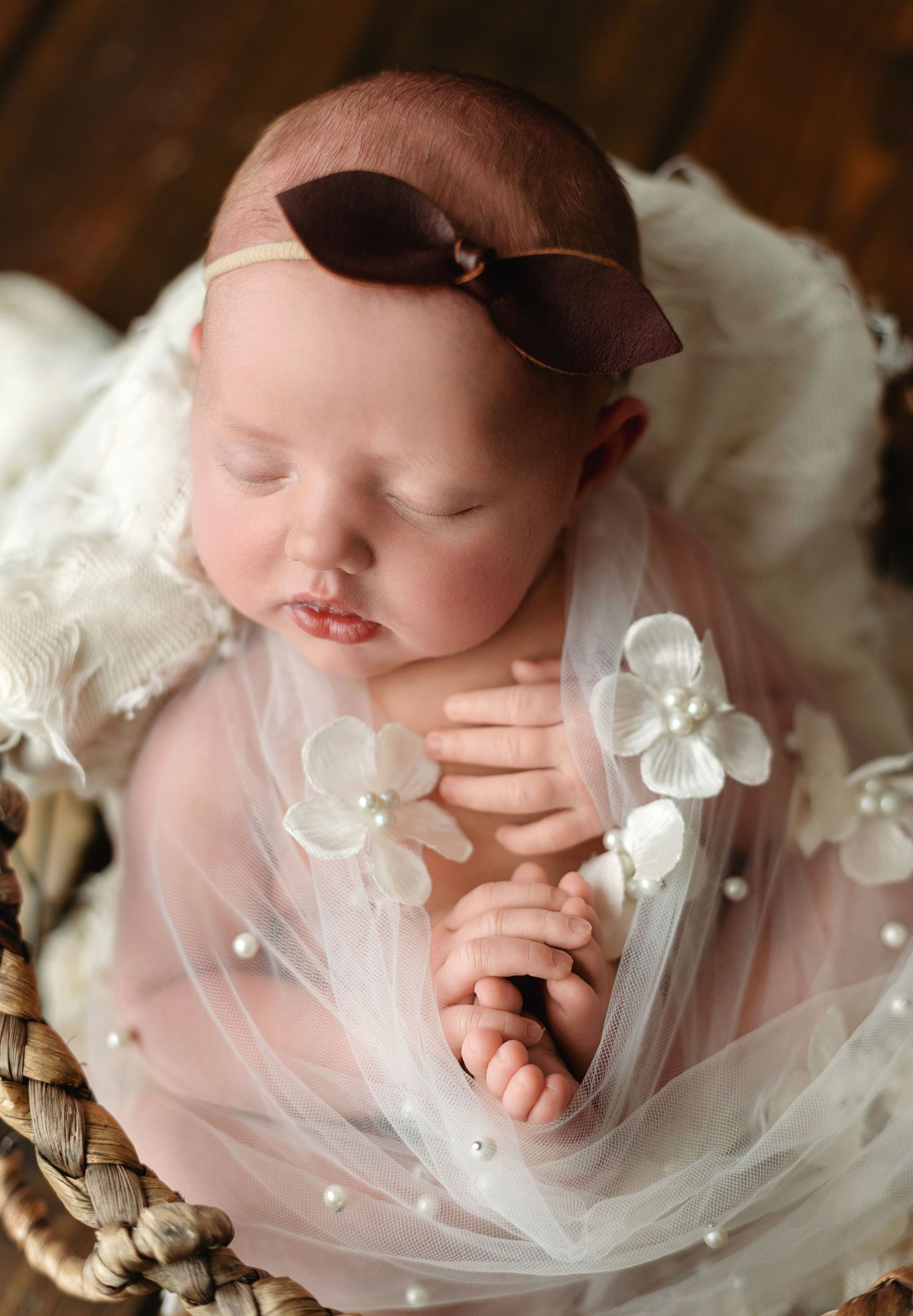 An up-close shot of a newborn girl wrapped in a sheer wrap with flowers on it.  - Greenville SC newborn photographer - Easley SC newborn