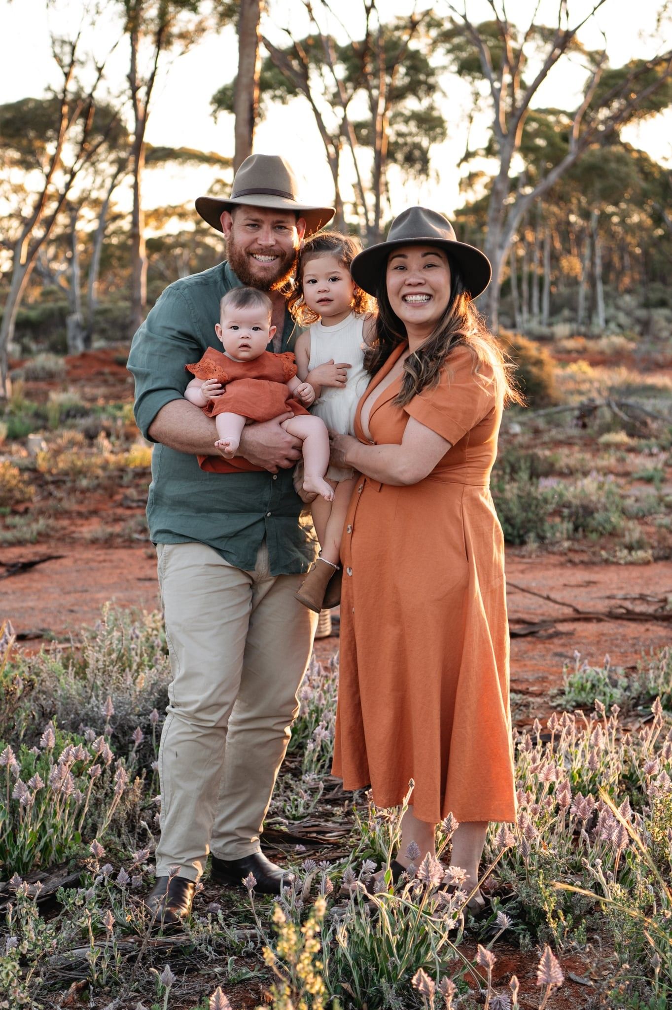 Children stroll along a rustic path at sunset during a golden hour outdoor family photo session.