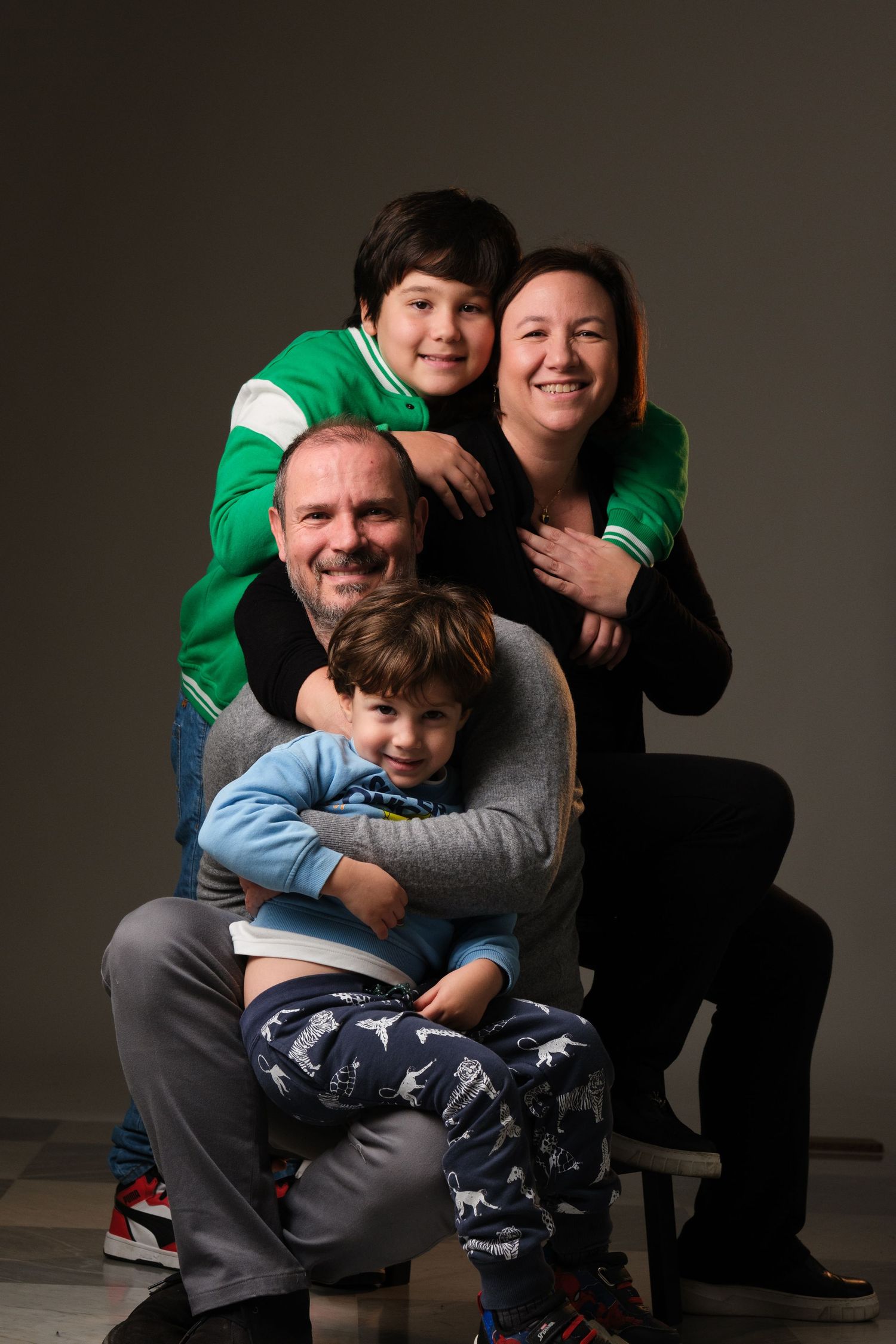 A series of casual family portraits showing warm embraces and smiles against a dark background.