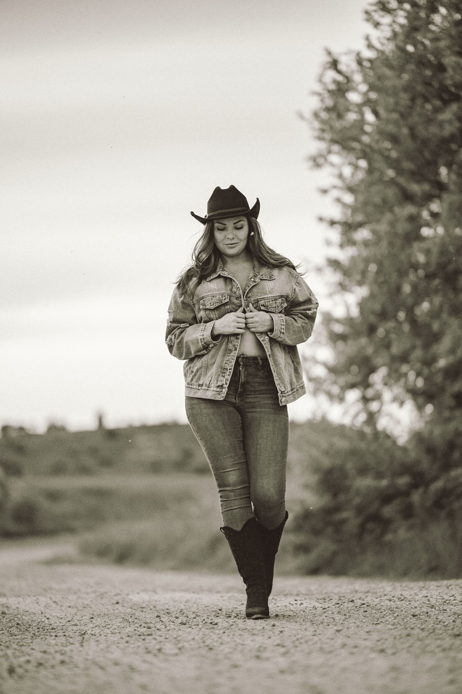 Svartvitt porträtt Malmö – kvinna i cowboyhatt och jeansjacka i kreativ pose | Werlerstam Photography