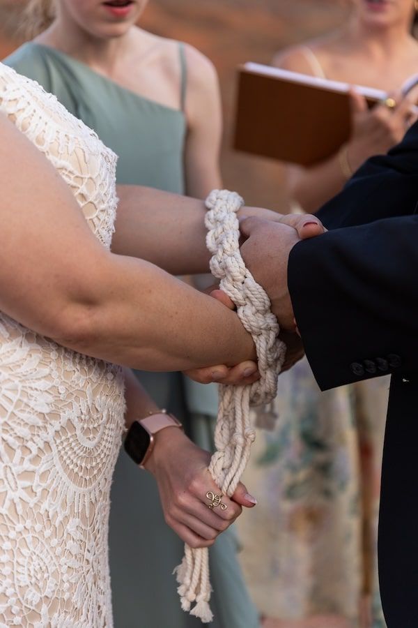 Close-up details of a white lace wedding dress sleeve with delicate patterns and intricate embroidery.