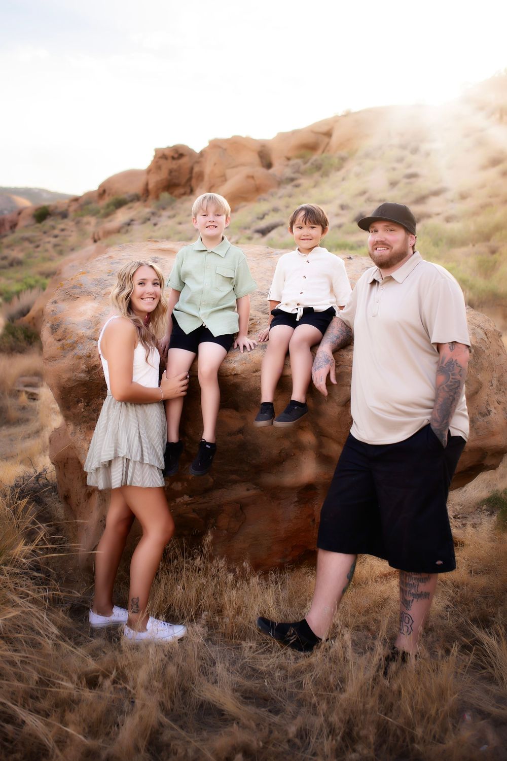 A progressive series of playful outdoor family portraits taken against desert rocks at sunset with coordinating neutral clothing.