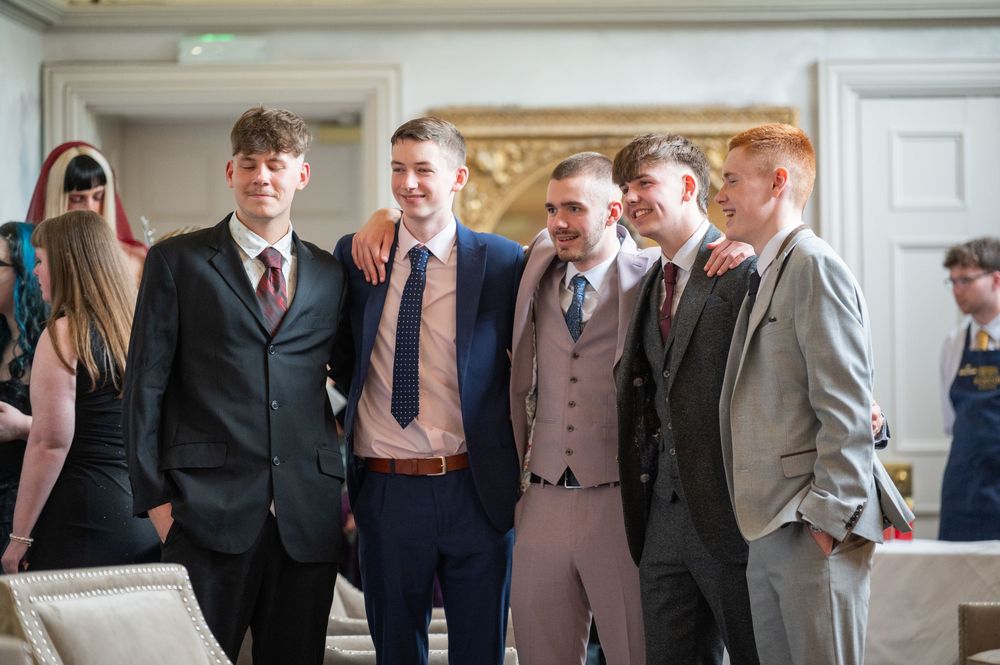 Group of formally dressed guests gathered for a celebratory event indoors.