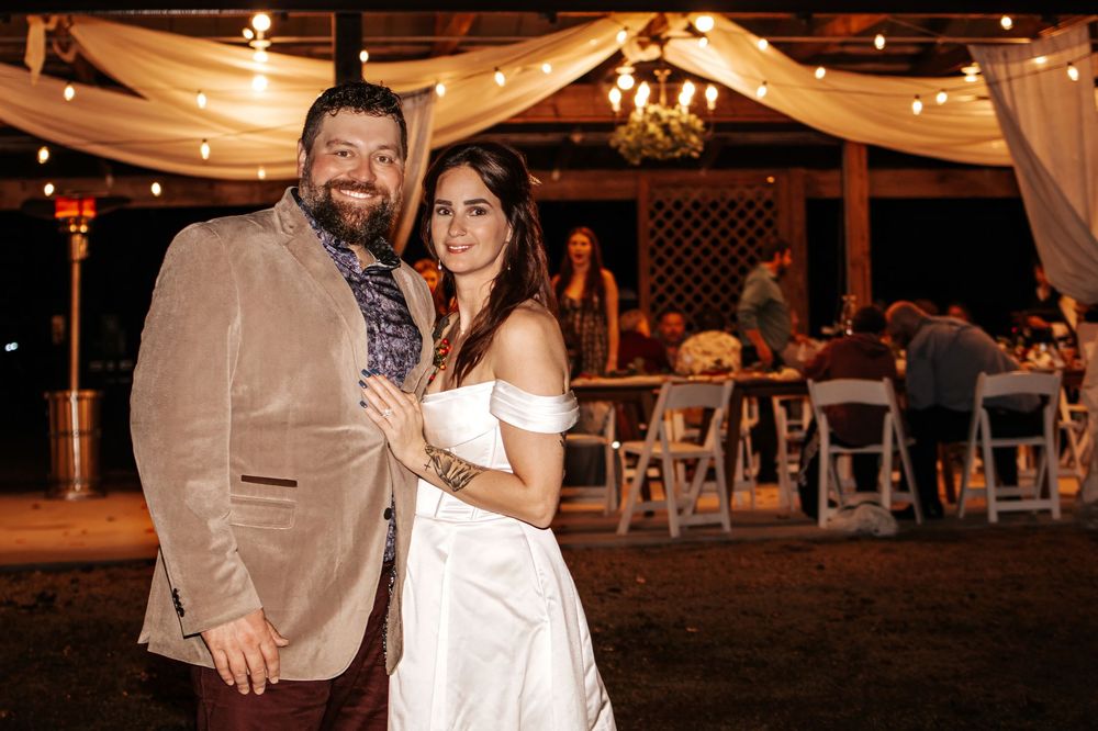 a close up portrait of a bride and groom standing in front of their venue