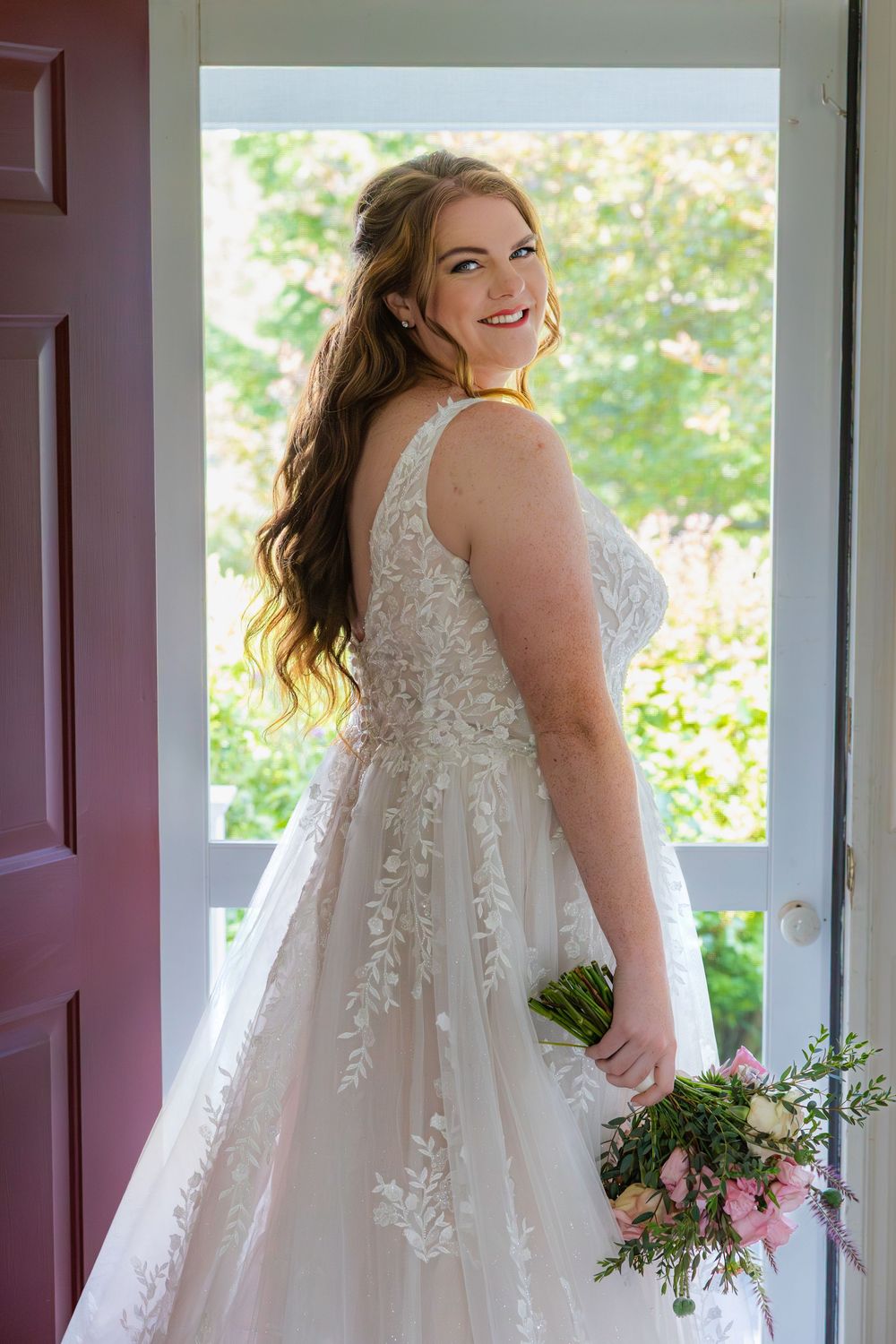 White lace wedding dress with floral appliques shown from multiple angles against a bright window backdrop.
