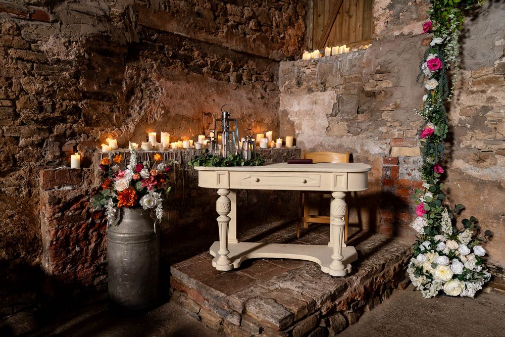 Flowers, table and candles in the rustic chapel at Ash Barton Estate in Devon.