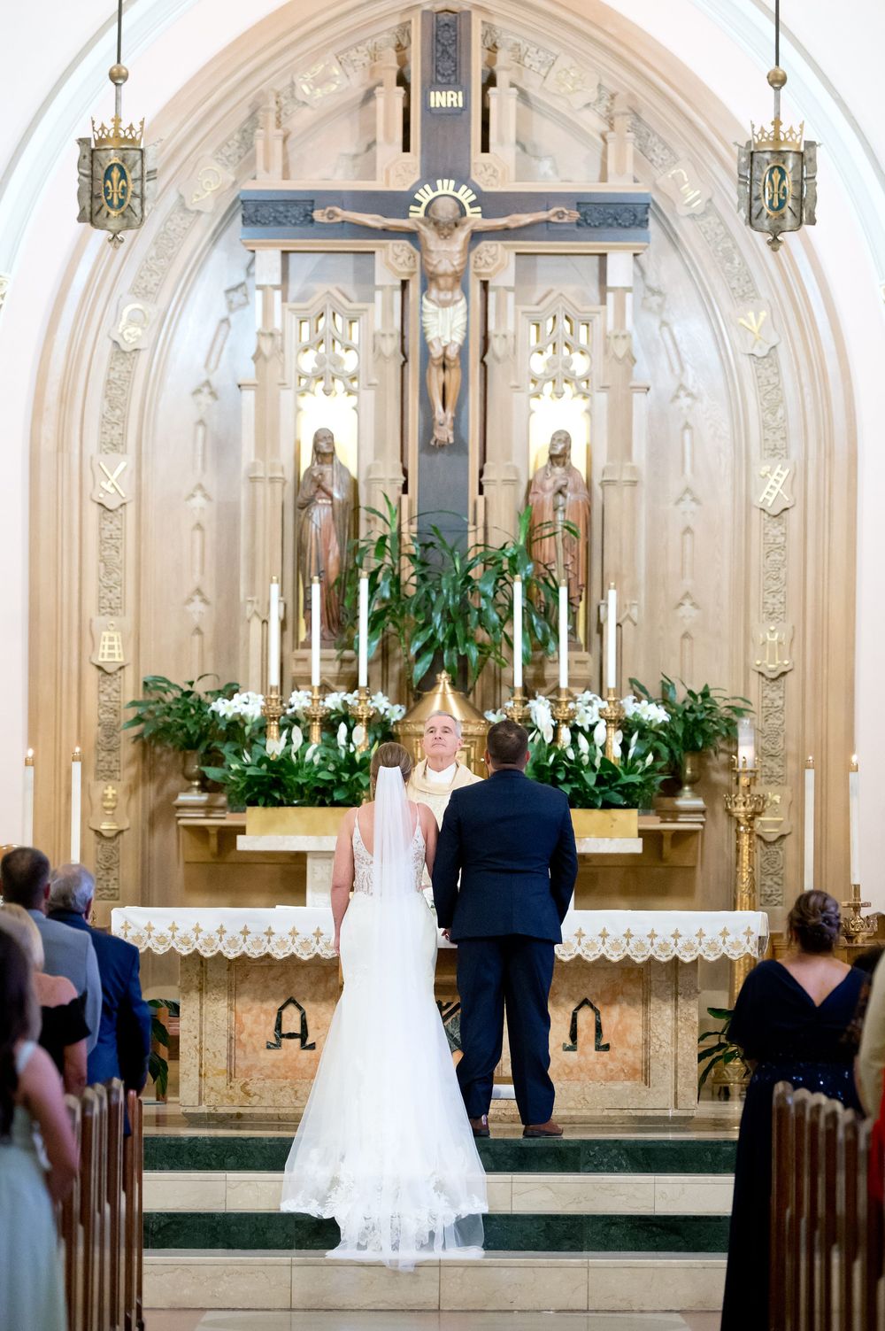 Bride and groom standing at the altar during a Catholic church wedding ceremony.