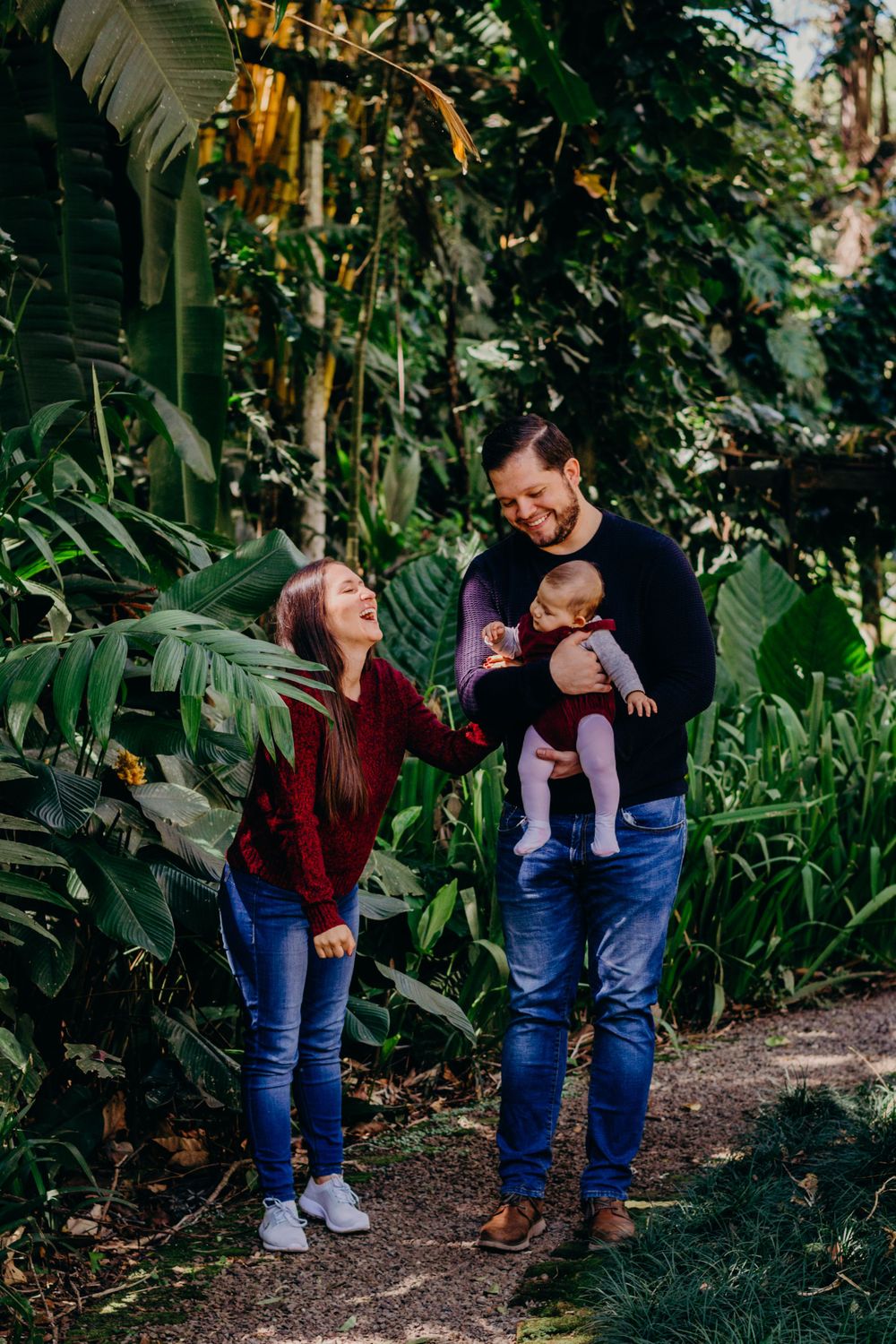 Candid family moment shared on a path through lush tropical foliage.