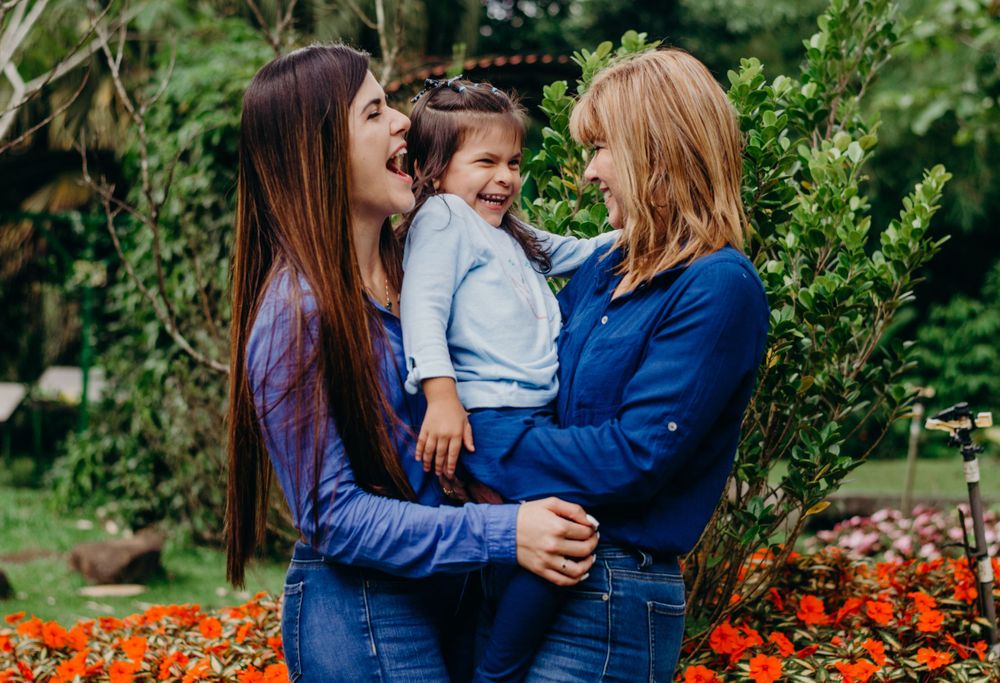A joyful family moment together in a garden with blooming orange flowers.