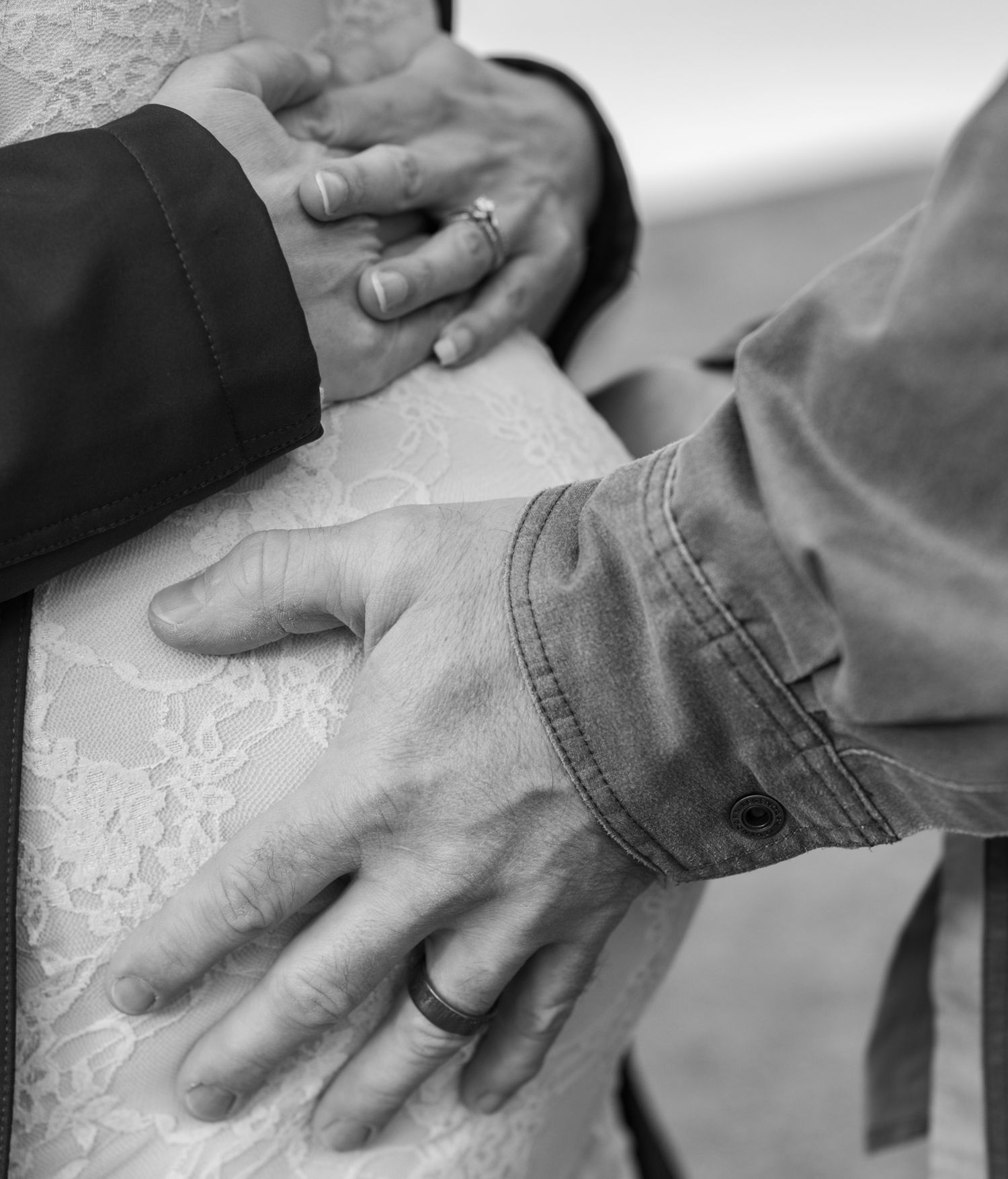Dad hands on pregnant mom belly.