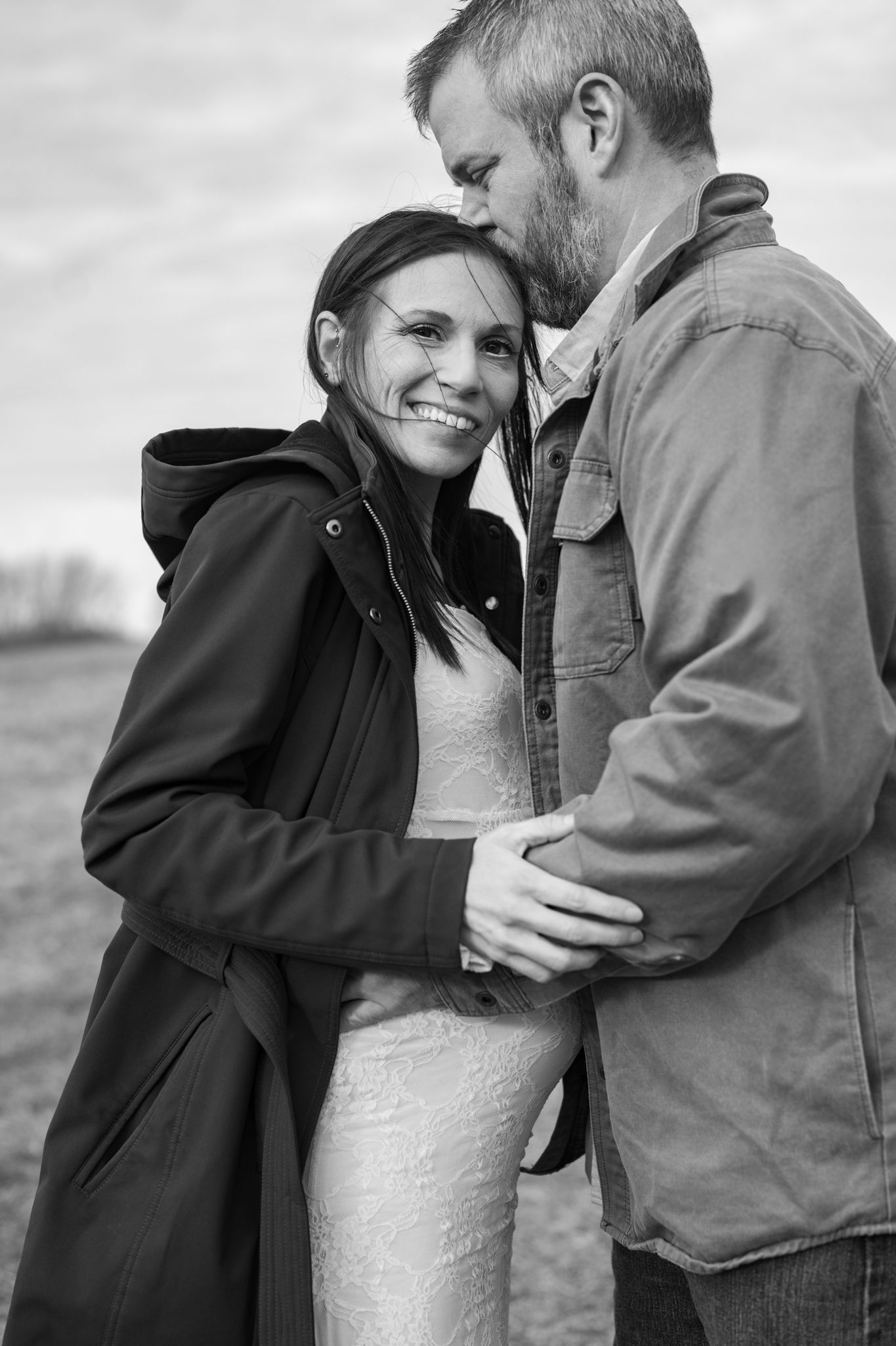 A husband kissing pregnant wife.