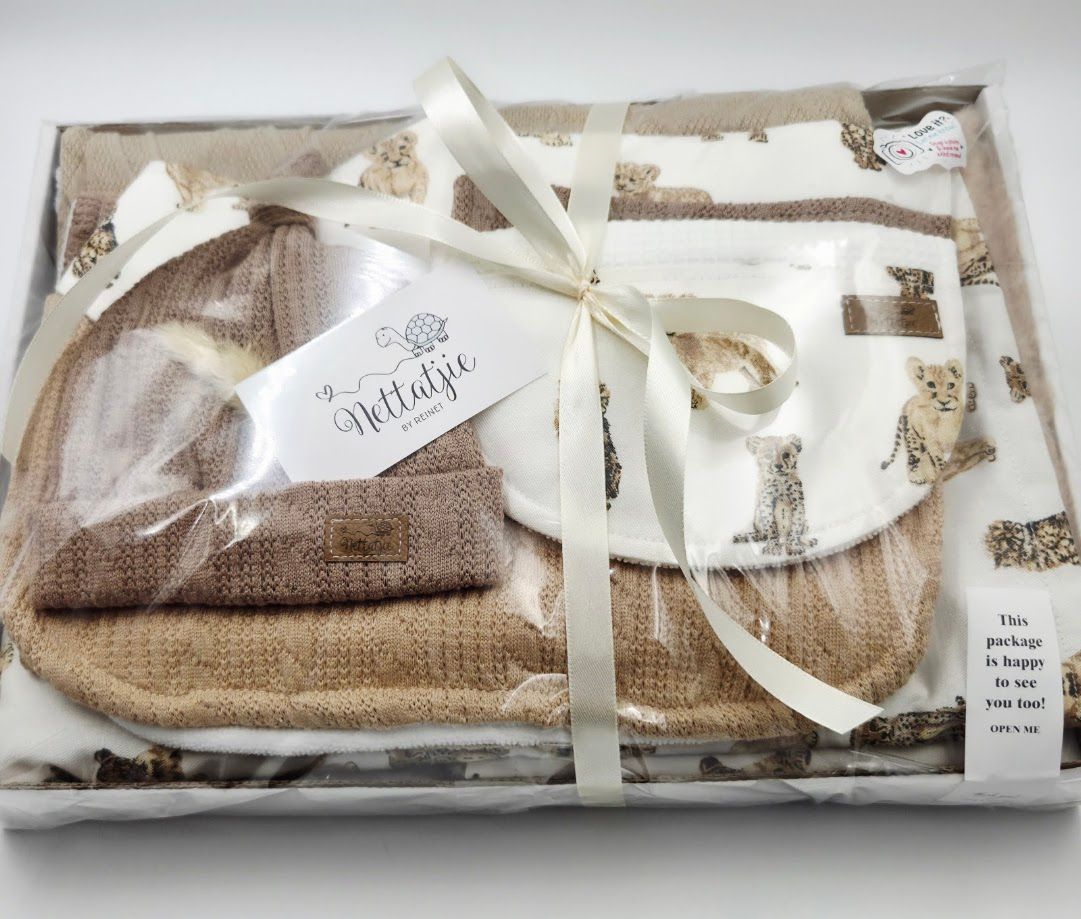 A gift box with baby clothes including striped onesie, white knit sweater, and soft shoes for a newborn.