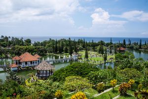 Panoramic view of Taman Ujung royal water palace in Bali surrounded by lush gardens and ocean views.