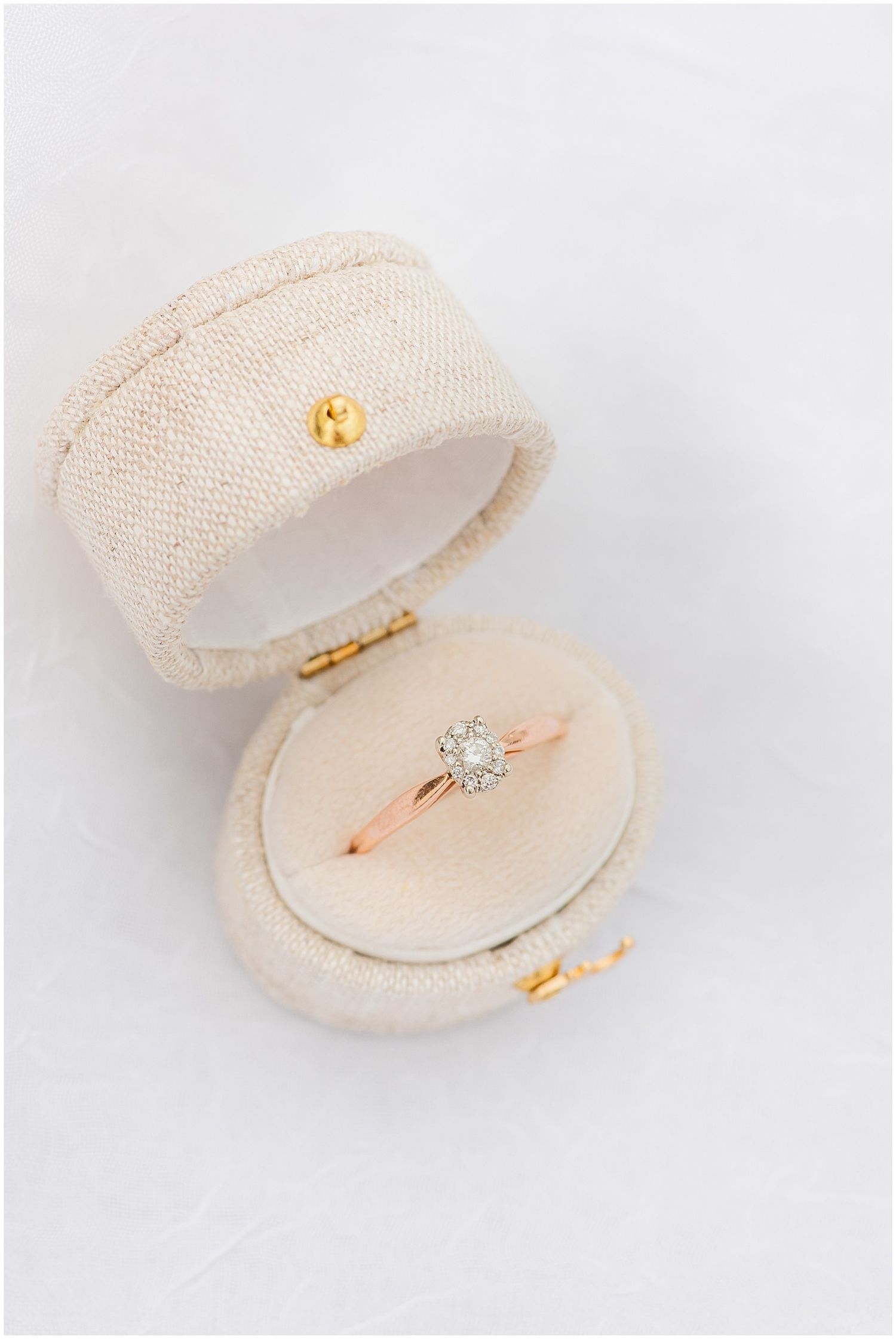 Elegant solitaire diamond ring on rose gold band displayed in open cream velvet ring box.