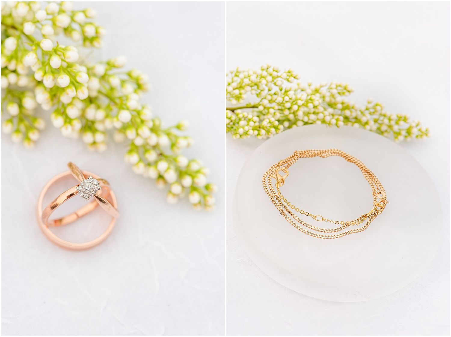 Rose gold wedding rings and delicate bracelet displayed with white floral sprigs on soft white background.