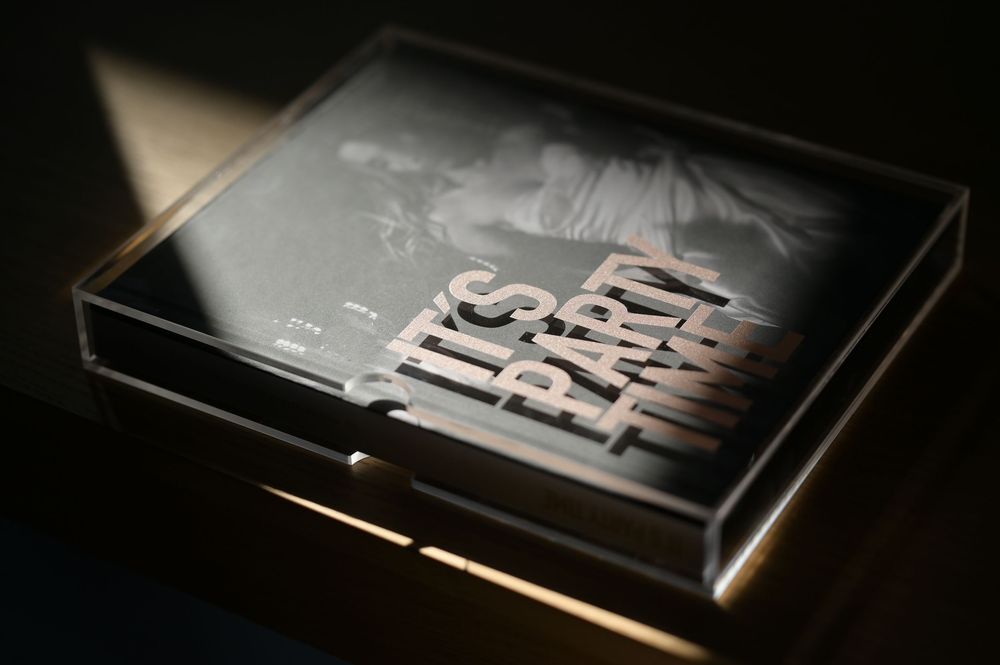Its Party Time photography book inside a transparent acrylic box in dramatic lighting.