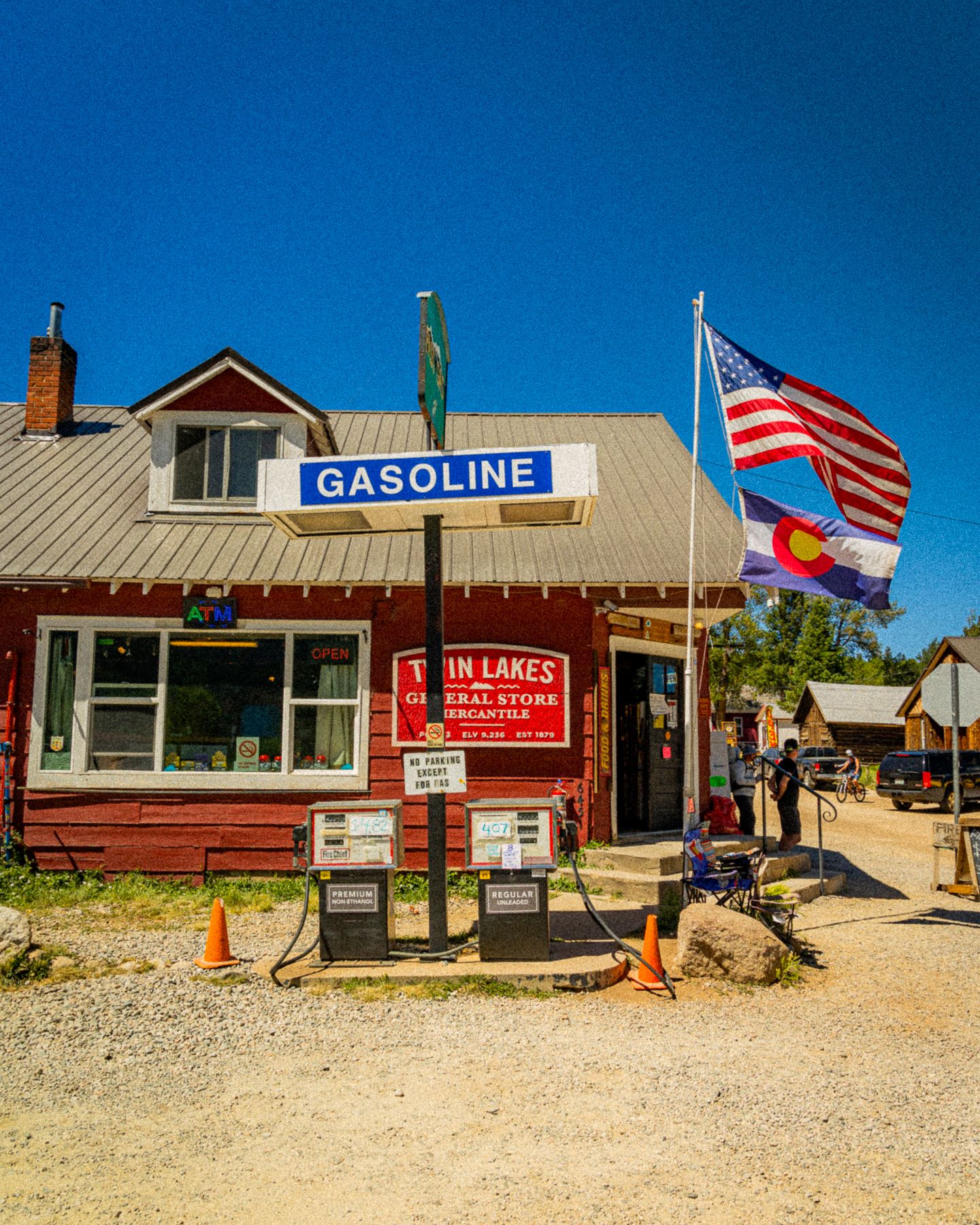 Twin Lakes General Store with gasoline pumps, American and Colorado flags, under a clear blue sky.