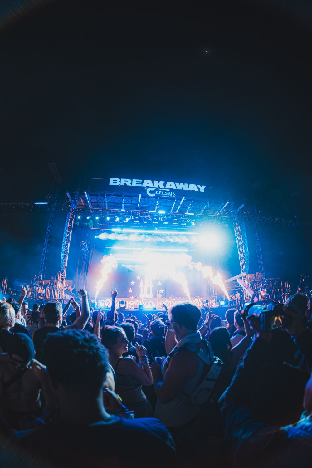 Energetic crowd at Breakaway Festival with blue stage lights at night.