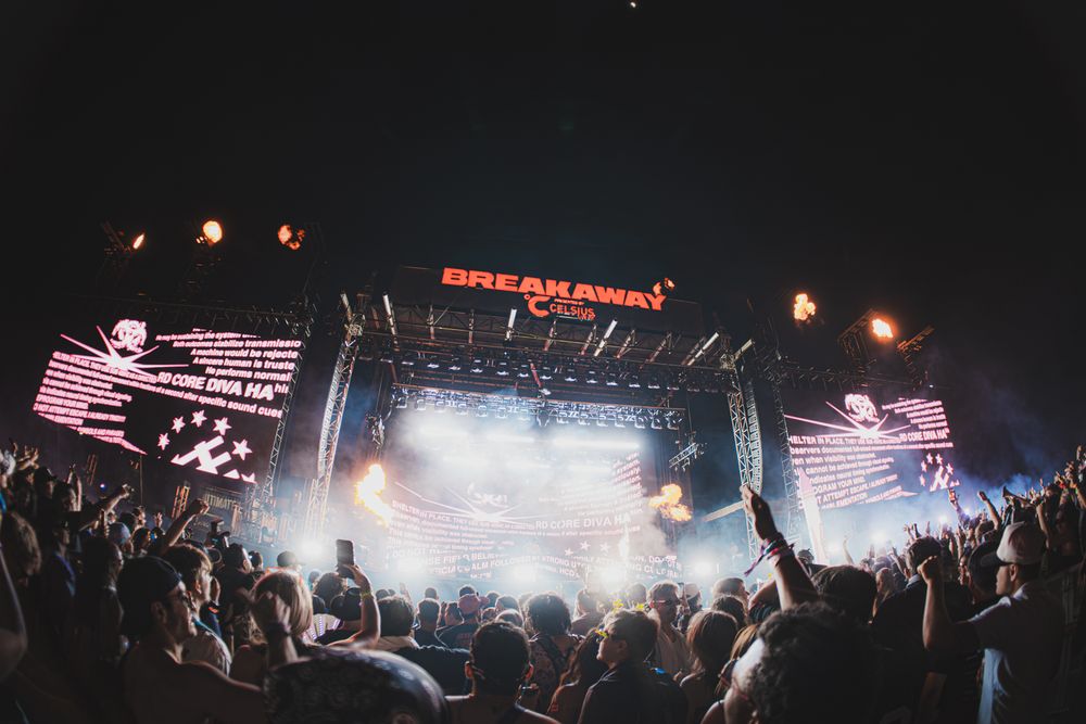 Crowd at Breakaway Music Festival enjoying a live concert with dramatic stage lighting and LED screens at night.