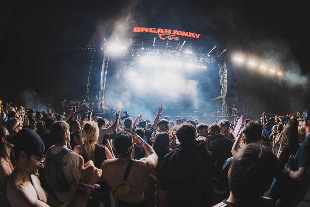 Massive crowd at Breakaway Music Festival enjoying a live concert under bright stage lights at night.