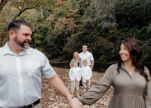 A family enjoys candid moments together during a fall outdoor photo session.