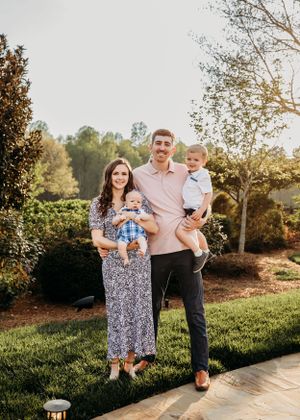 Family portrait session on a landscaped lawn during golden hour.