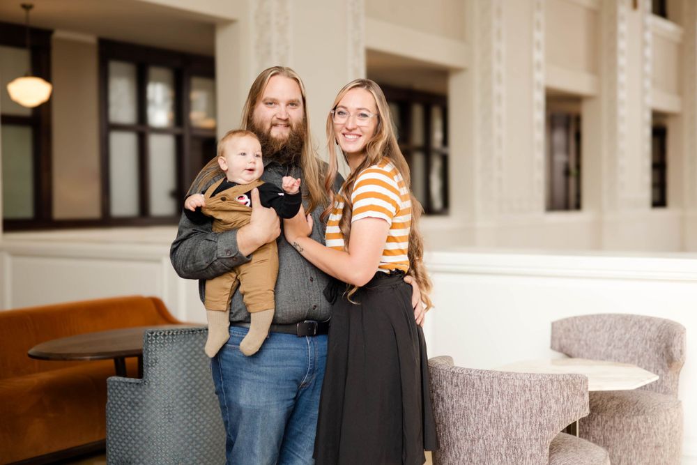 A family poses together in an indoor setting with modern decor and furniture.