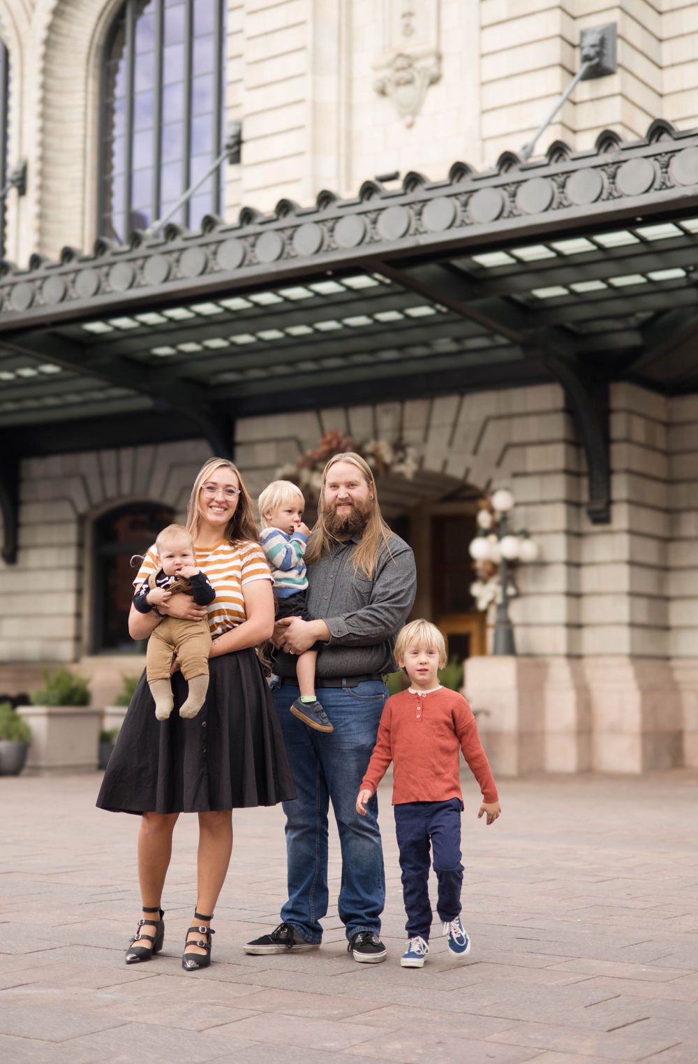 A family group poses outside a historic building with ornate architecture.