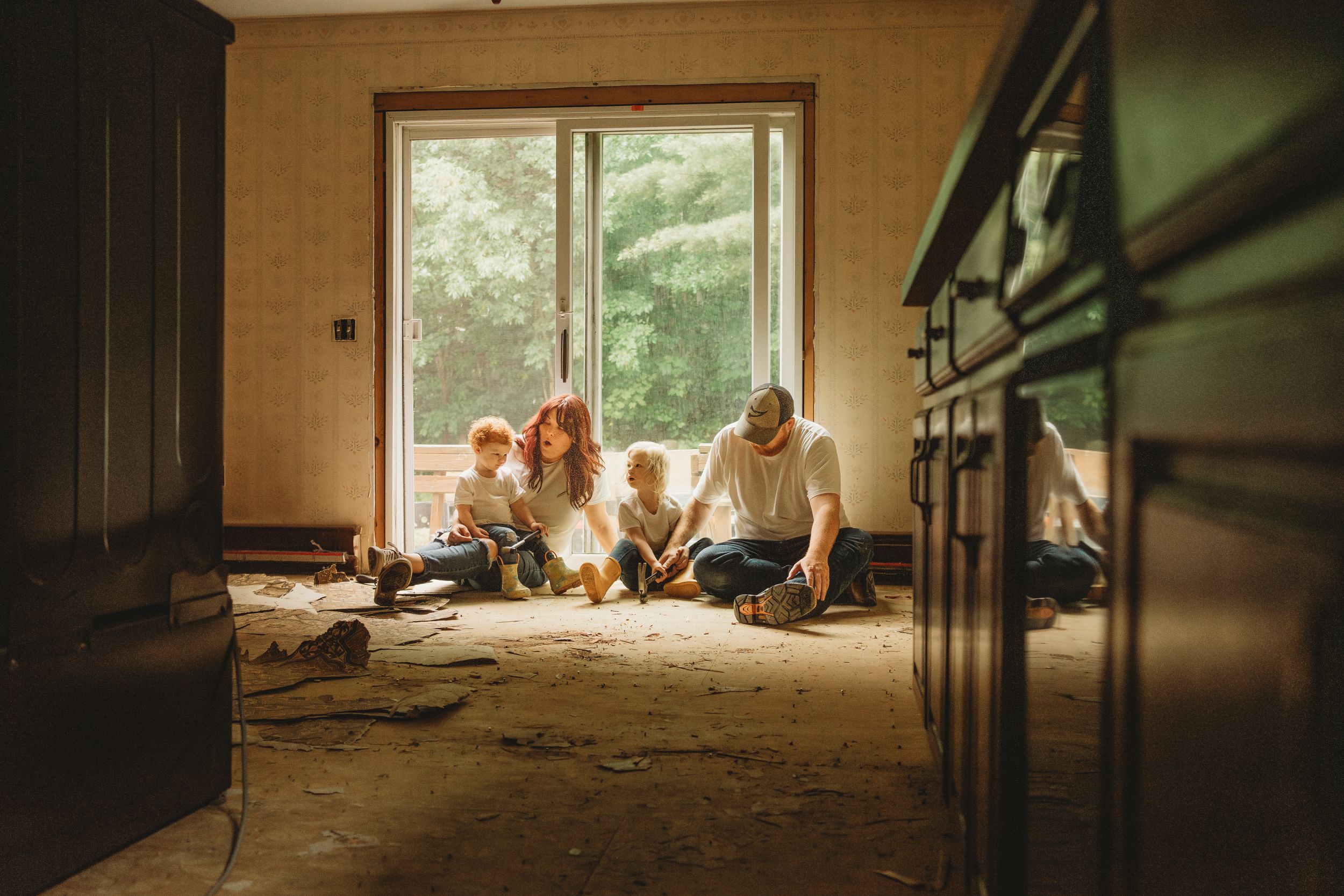 Family sitting on floor together during home renovation project.