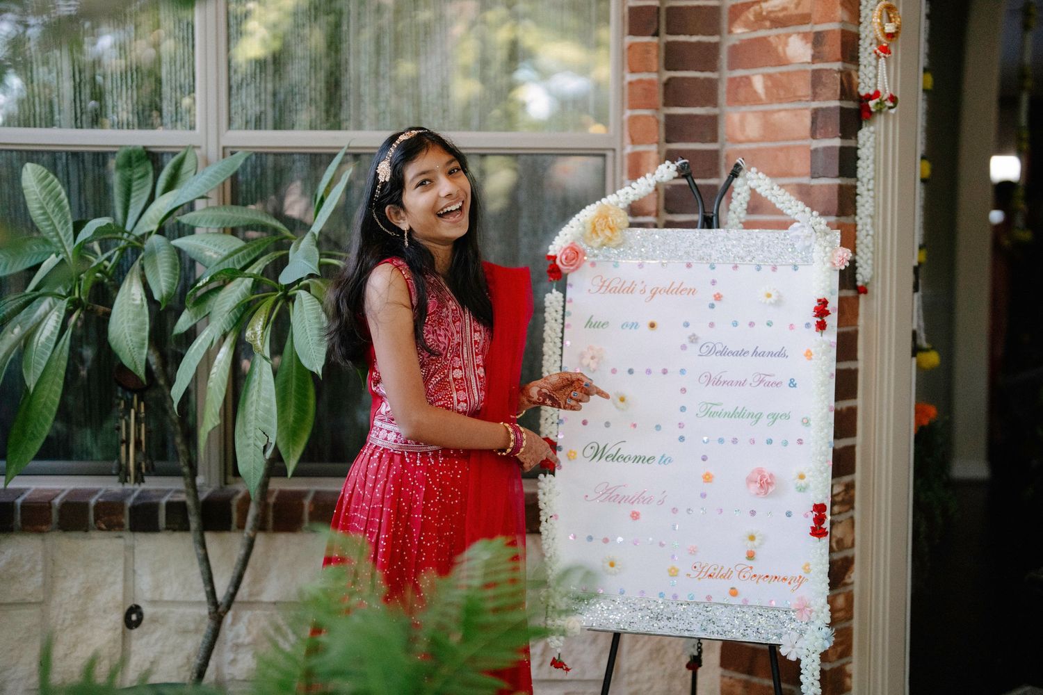 Someone in a red dress holds up a white poster board with writing and decorations in multiple photos.