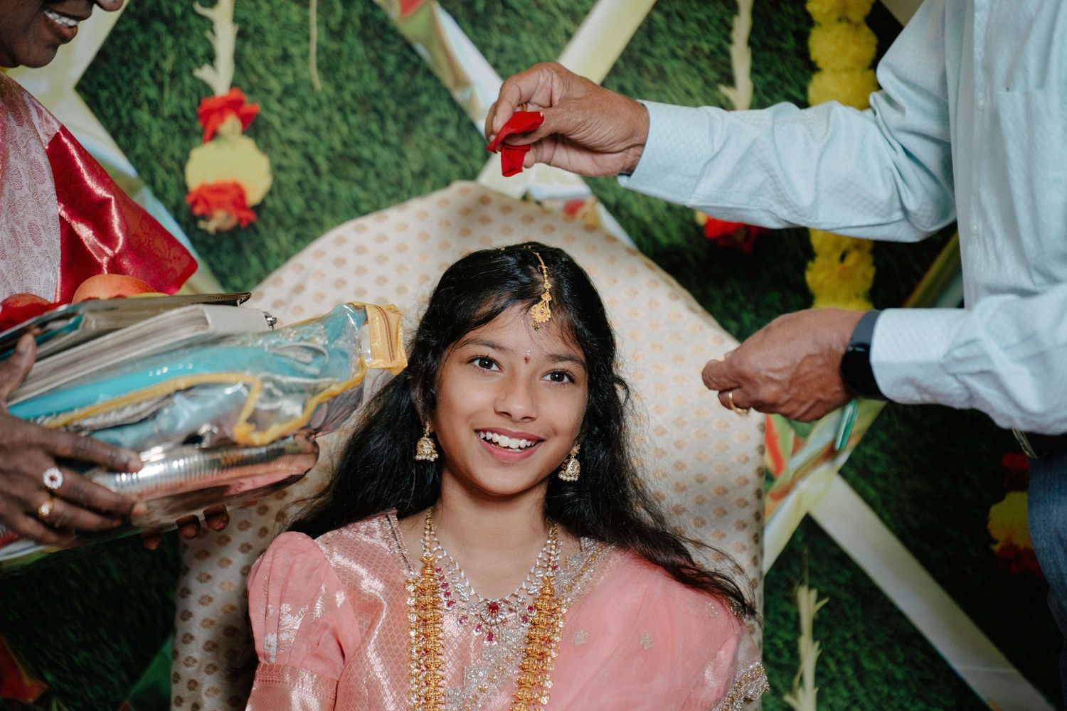 A group of people celebrate at a traditional Indian wedding ceremony with colorful decorations and traditional attire.