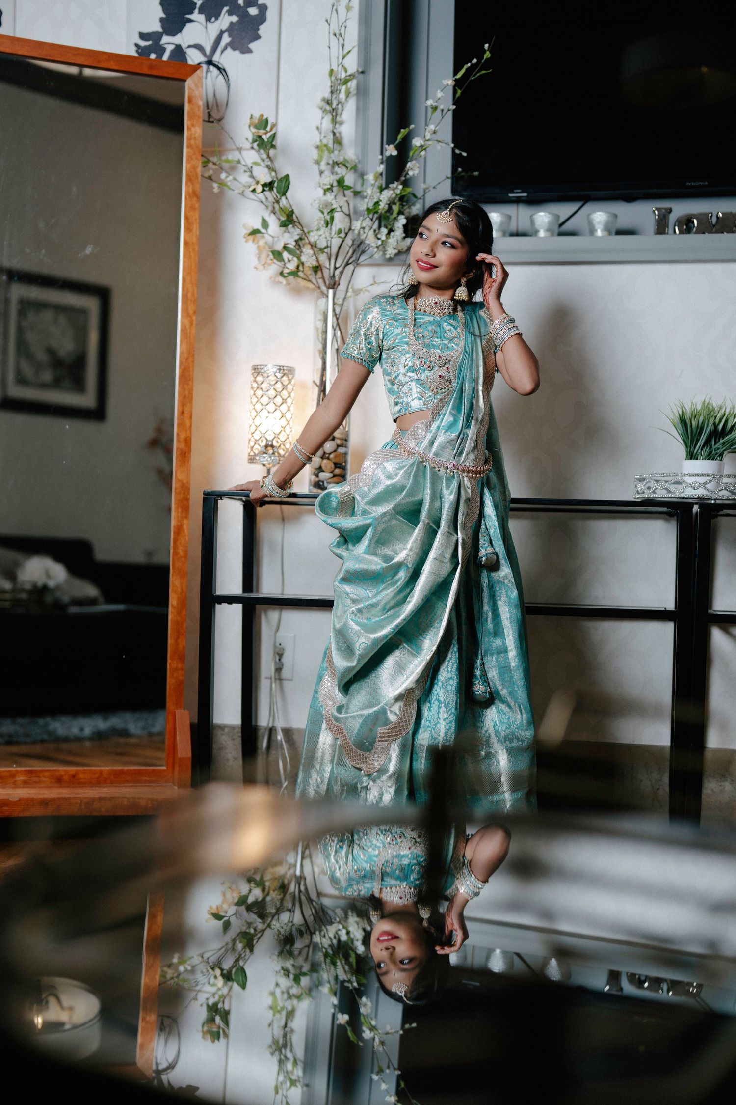 A series of playful dance poses in a mint green traditional saree against an indoor setting.