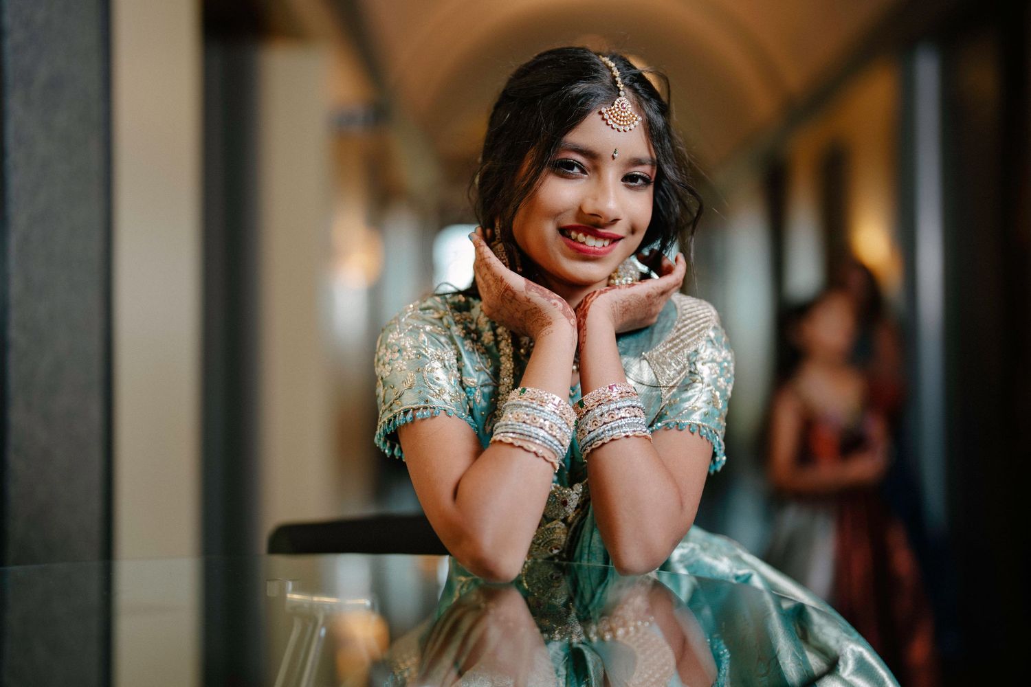 A person in a mint green traditional Indian dress poses elegantly in various indoor settings.