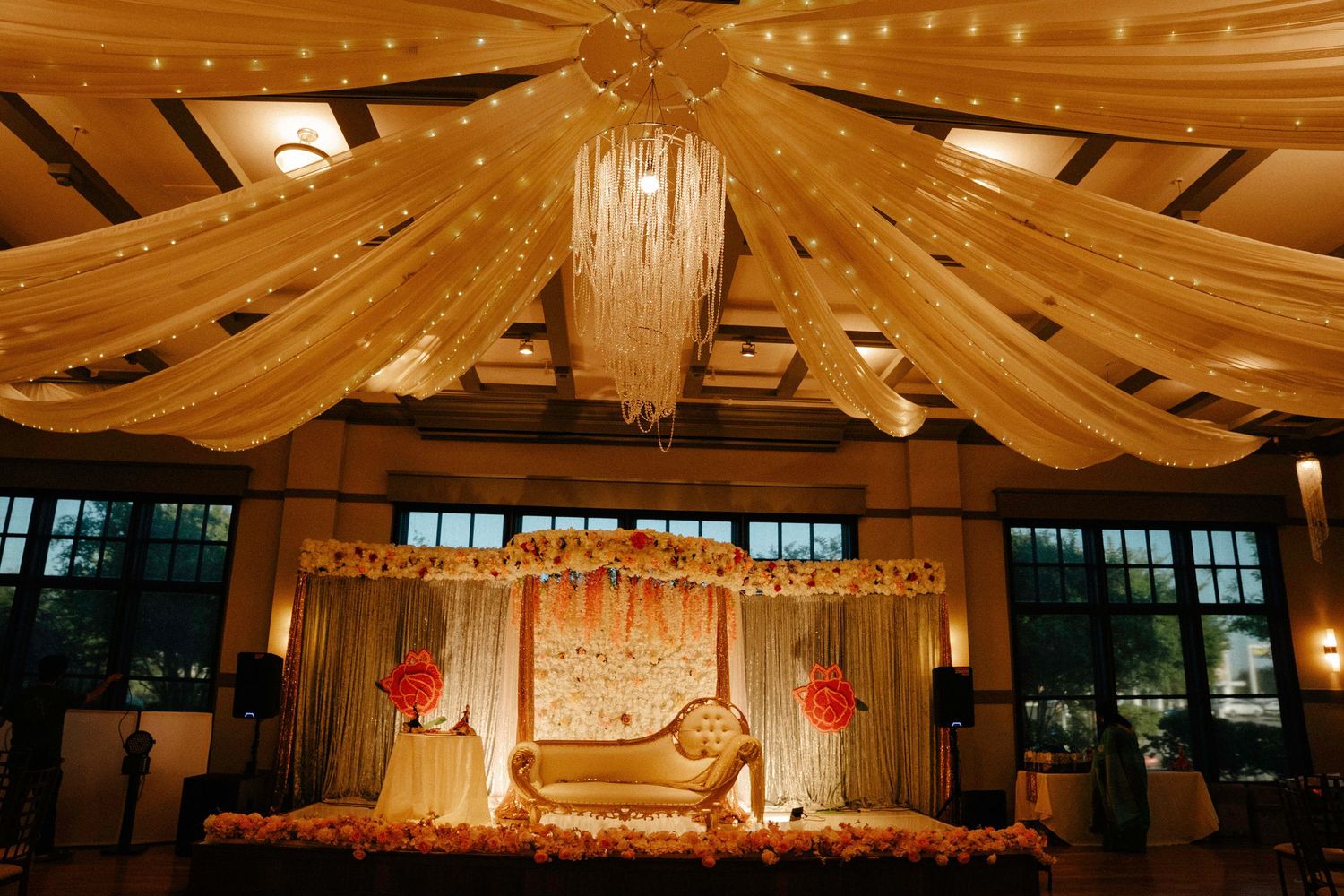 Wedding reception venue with draped fabric ceiling and romantic string lights.